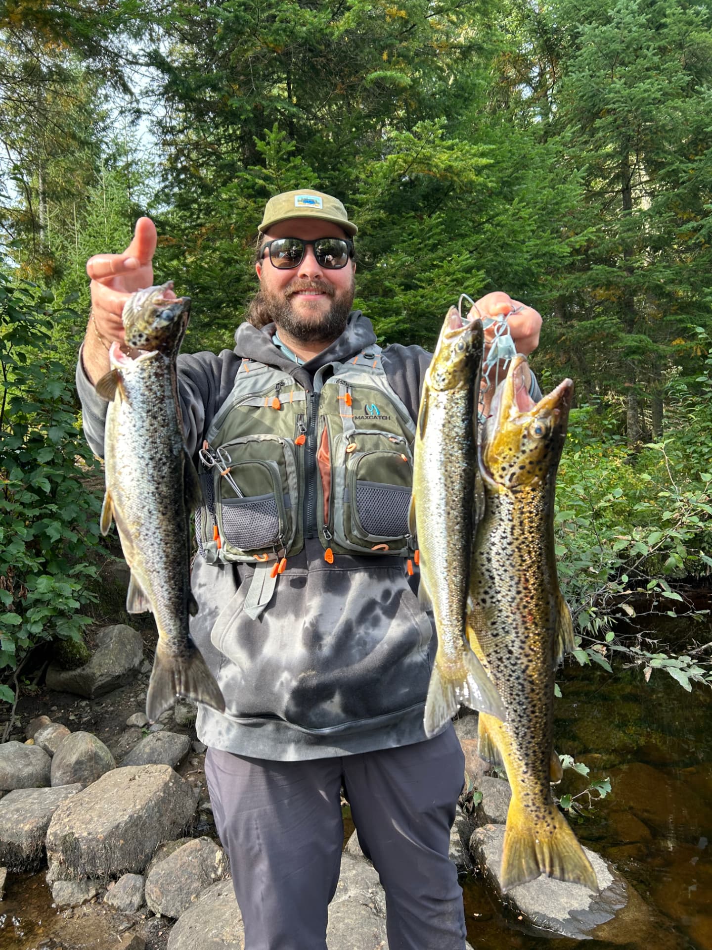 Guide de pêche souriant présentant trois ouananiches capturées près de Mont-Tremblant à la fin de la saison 2026