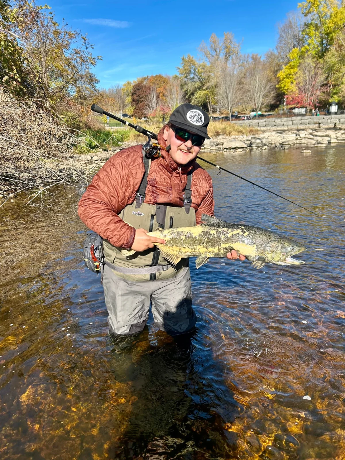 An angler holding a late-run Chinook with spawning colours in Kingston.
